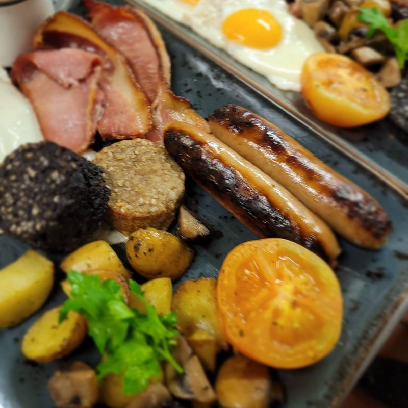 A cooked Irish breakfast on a slate-blue plate