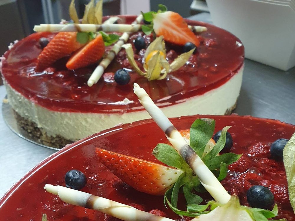 A berry-glazed cheesecake with strawberries, physalis and white chocolate curls
